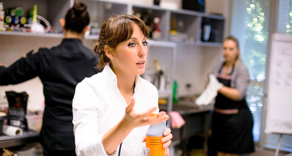 Chef donna istruzioni in cucina. Lezione di cucina, preparazione cibi.