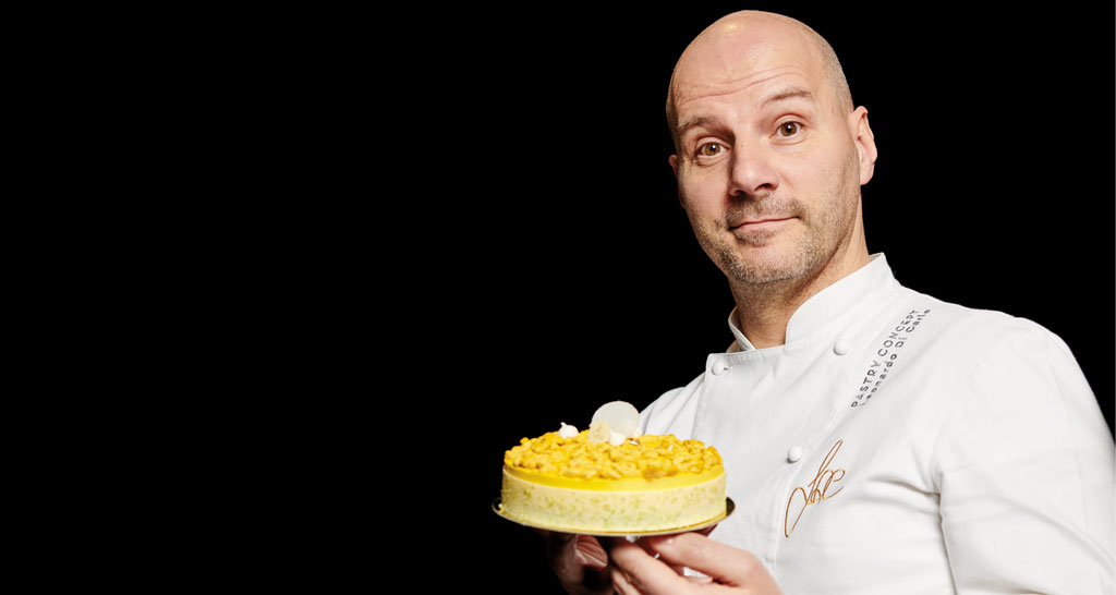Chef Leonardo Di Carlo con torta. Pasticceria di alta qualità.