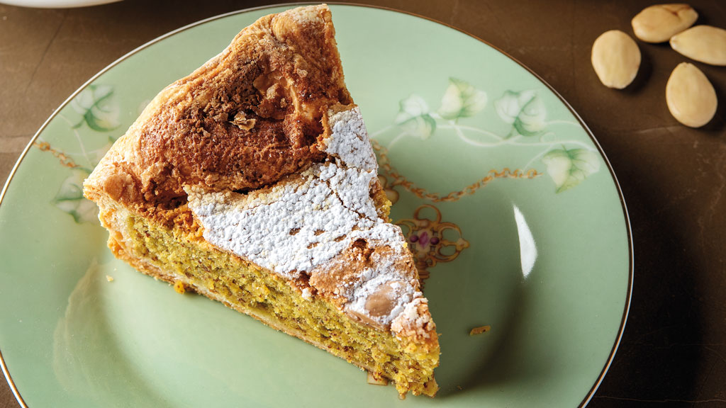 Fetta di torta caprese alle mandorle su piatto decorato. Dolce tipico italiano, ricetta tradizionale.