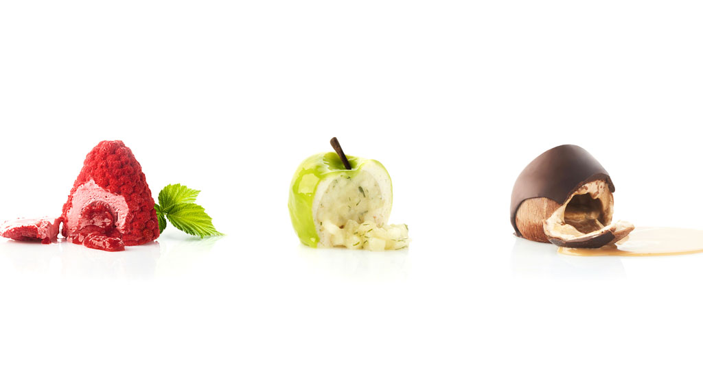 Composizione artistica di frutta: lampone, mela verde e castagna. Natura morta creativa.