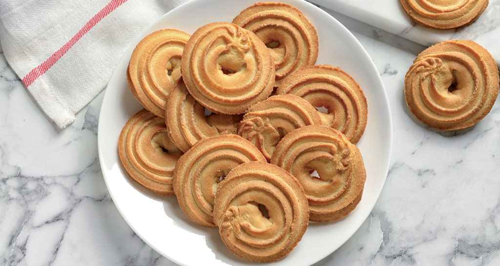 Biscotti danesi al burro su piatto bianco. Deliziosi biscotti perfetti per la colazione o il tè.