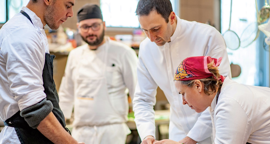 Team di chef al lavoro in cucina. Ristorante, preparazione cibo, professionisti culinari.