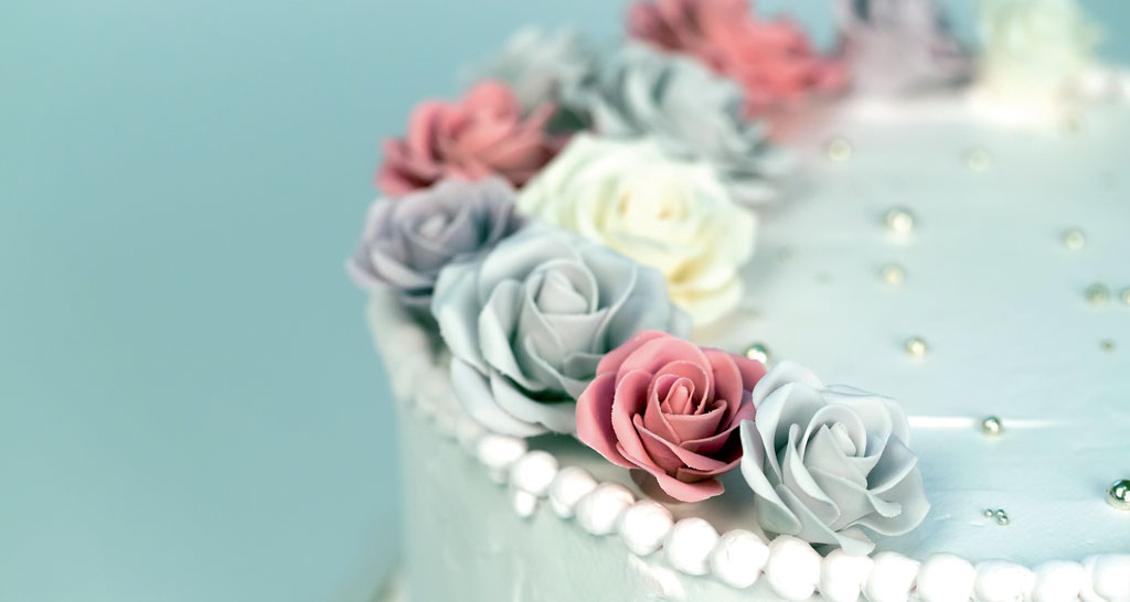 Torta nuziale decorata con rose pastello e perle. Idea per matrimonio, pasticceria.