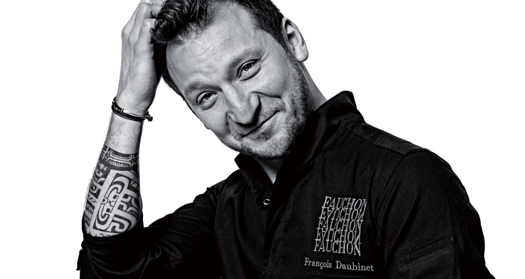 Ritratto in bianco e nero dello chef François Daubinet con tatuaggio sul braccio.