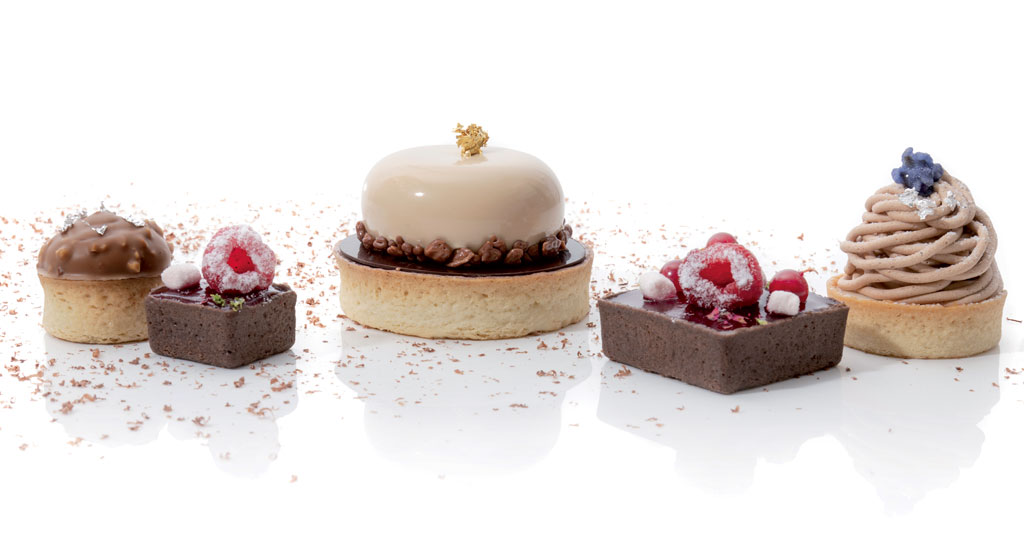 Pasticceria artigianale: mini torte assortite con cioccolato, frutta fresca e crema. Dolci deliziosi per ogni occasione.