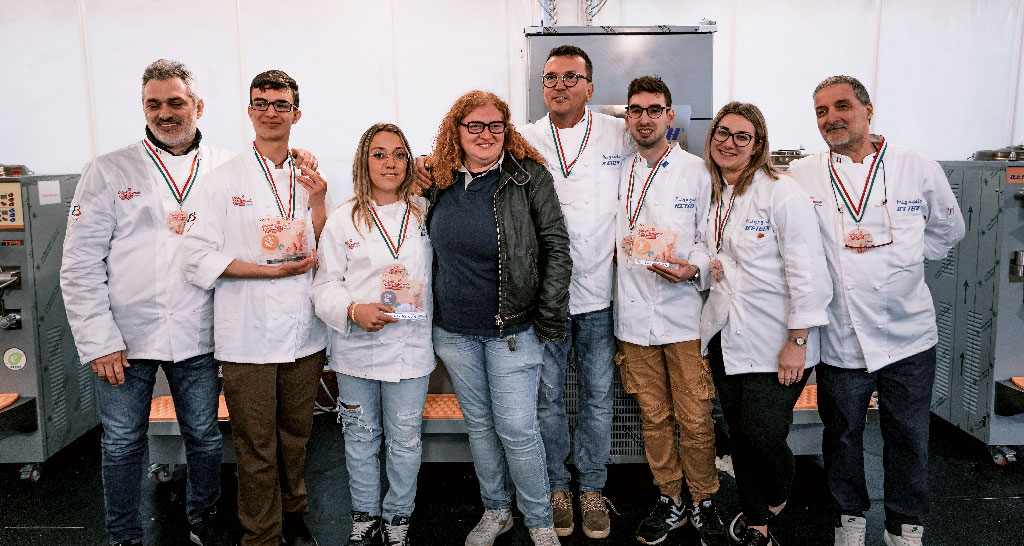Team di gelatieri al Festival del Gelato di Pesaro. Medaglie e sorrisi per il gelato artigianale.