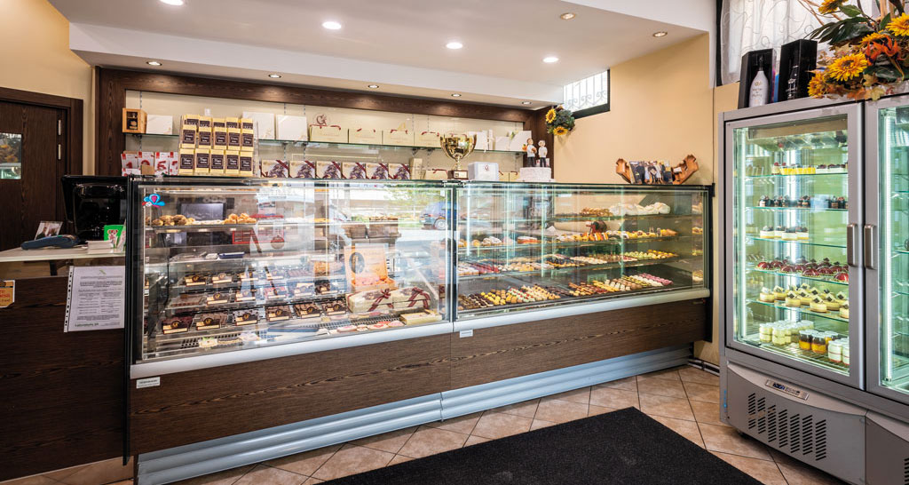Vetrina pasticceria con dolci assortiti, torte e cioccolatini. Delizie da forno e pasticcini freschi. Ideale per colazione e dessert.