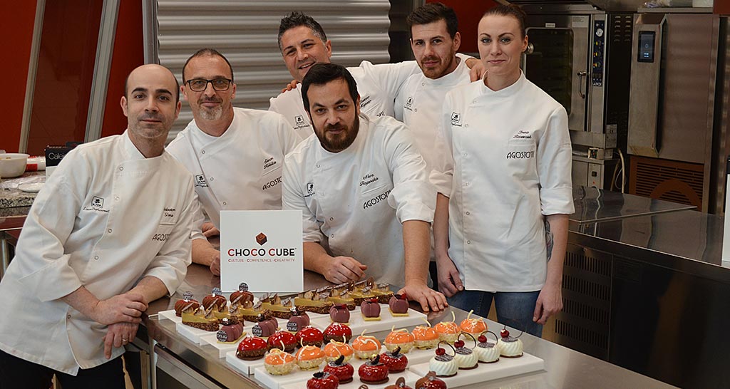 Team tecnico di pasticceria con dolci assortiti. Chef professionisti. Choco Cube.