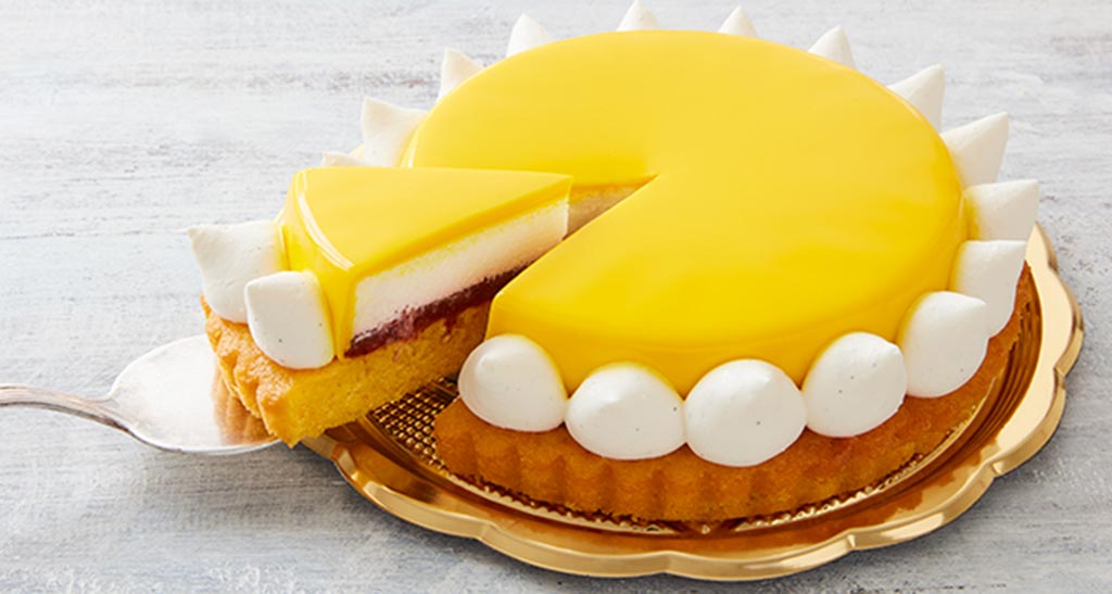 Torta Elisenda al limone con glassa gialla e panna. Dessert fresco e invitante.