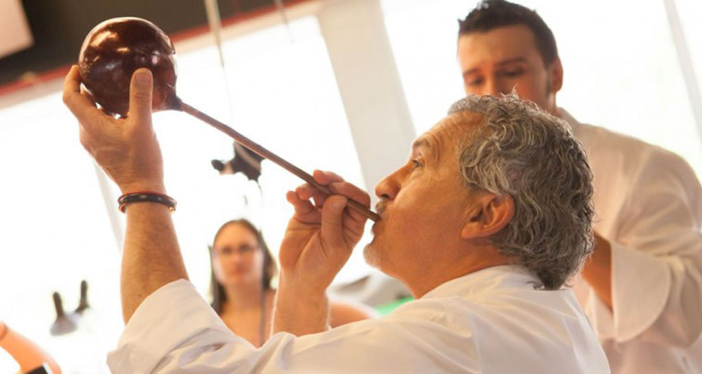 Paco Torreblanca, maestro pasticcere, crea una sfera di cioccolato soffiando con una cannuccia. Arte culinaria.