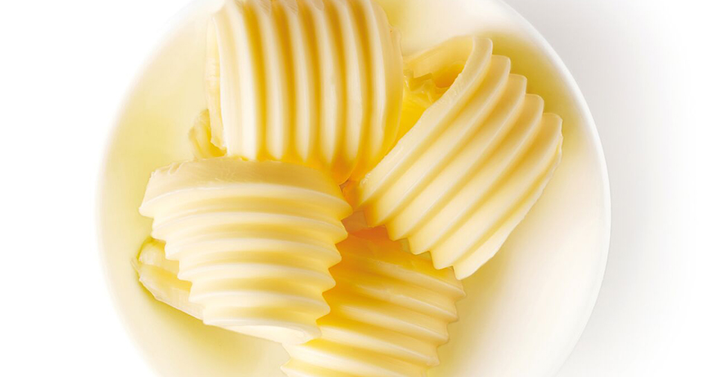 Riccioli di burro freschi in ciotola. Burro di alta qualità per ricette gustose.