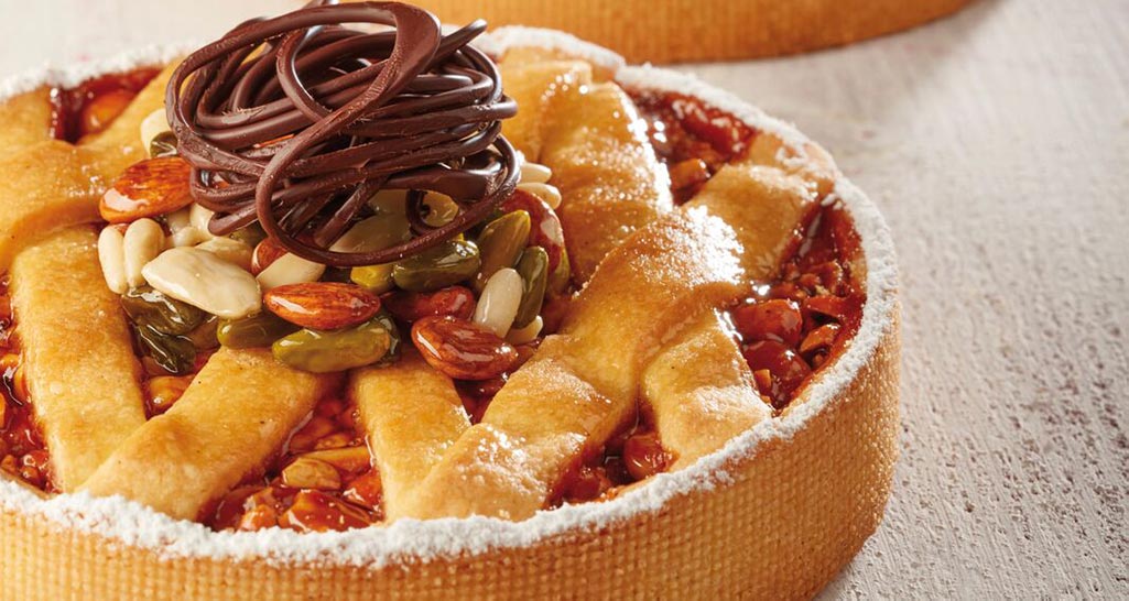 Crostata artigianale con frutta secca e decorazioni di cioccolato. Dolce da forno, pasticceria italiana.