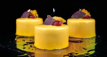 Tre eleganti mini torte gialle con decorazioni. Pasticceria raffinata.