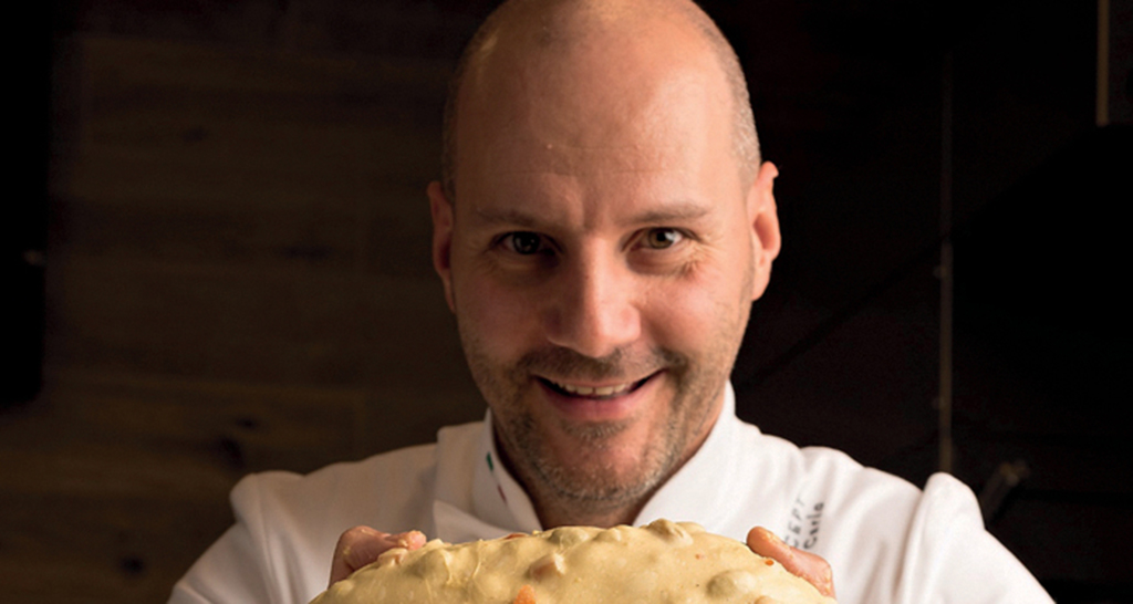 Chef Di Carlo con pizza. Cucina italiana di alta qualità.
