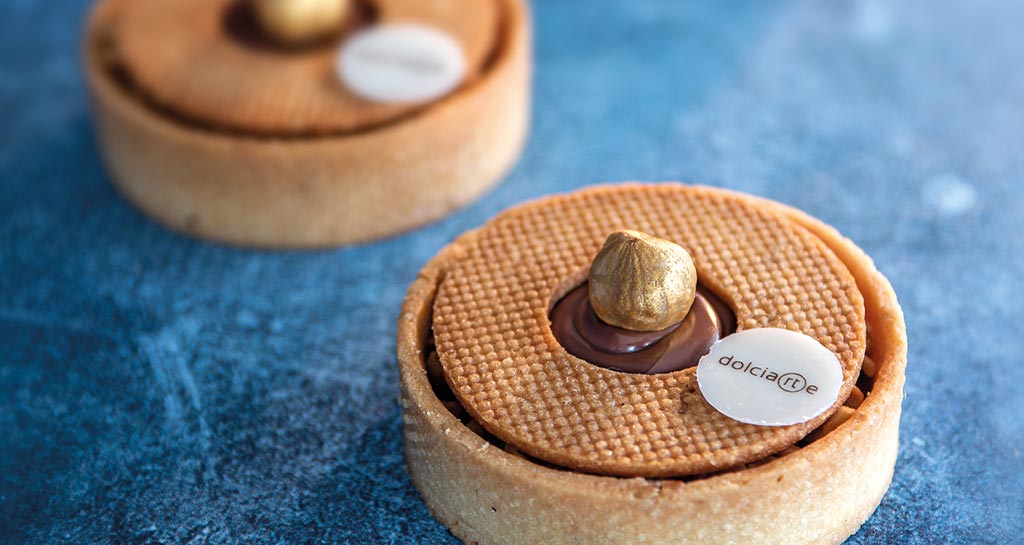 Crostata gianduia artigianale con nocciola dorata. Pasticceria raffinata, dessert goloso.