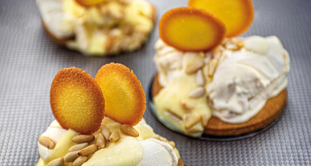 Monoporzioni dolci: dessert con crema, biscotti e pinoli. Pasticceria artigianale.