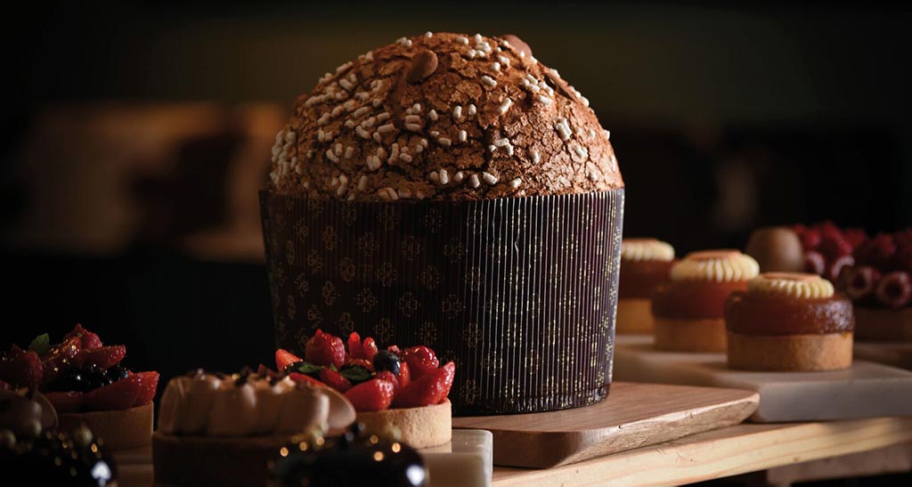 Panettone artigianale con glassa e decorazioni. Dolci natalizi e pasticcini.