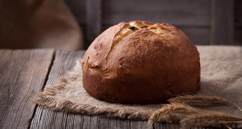 Panettone artigianale su legno. Dolce tipico italiano, ideale per Natale e feste.