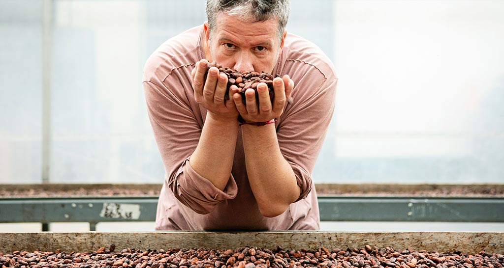 Ernst Knam annusa fave di cacao. Chef esperto di cioccolato.