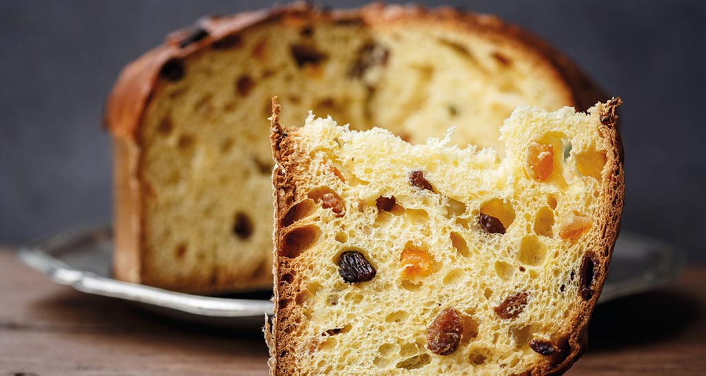 Panettone artigianale con canditi e uvetta. Dolce tradizionale natalizio italiano.