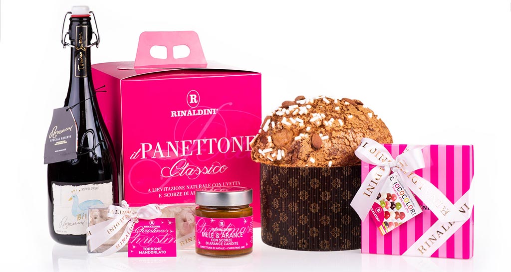 Cesto natalizio Rinaldini: panettone classico, vino, torrone, mele e arance candite. Idea regalo gourmet.