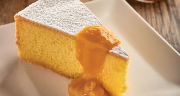 Fetta di torta soffice con glassa all'arancia e zucchero a velo. Dolce da forno.