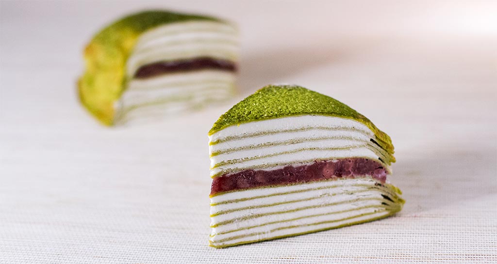 Fetta di torta millecrepe al matcha con ripieno di fagioli rossi azuki. Dolce giapponese.