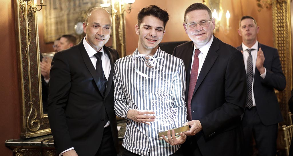 Vincitore Chococake Award con premio. Uomo sorridente con trofeo, evento di premiazione, successo e riconoscimento.