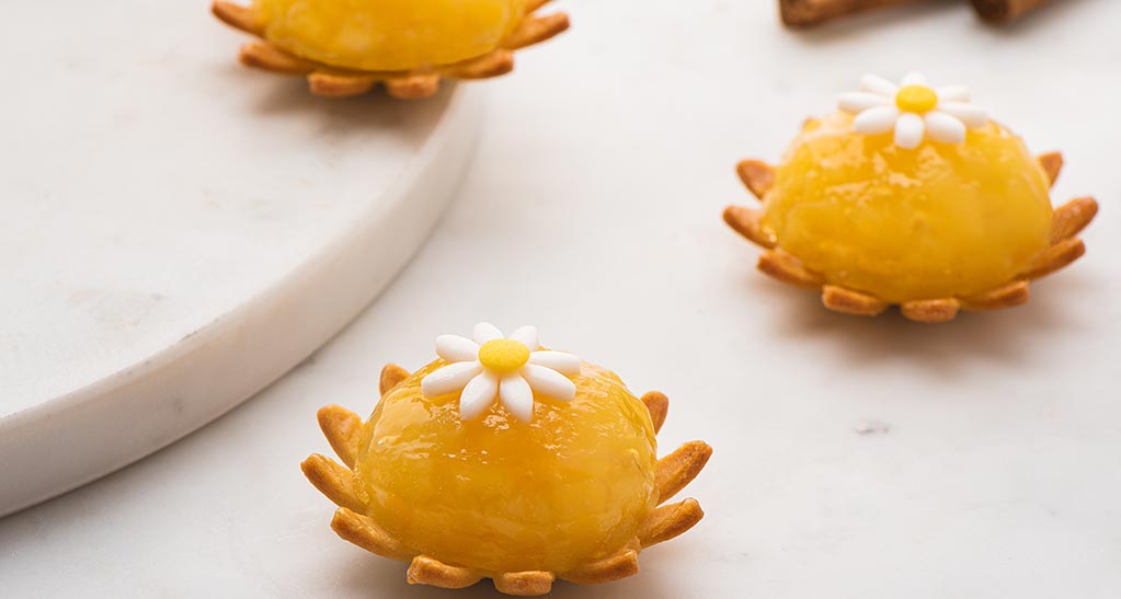 Mini tortine al limone con decorazione a margherita. Dolci freschi e gustosi, perfetti per la primavera.