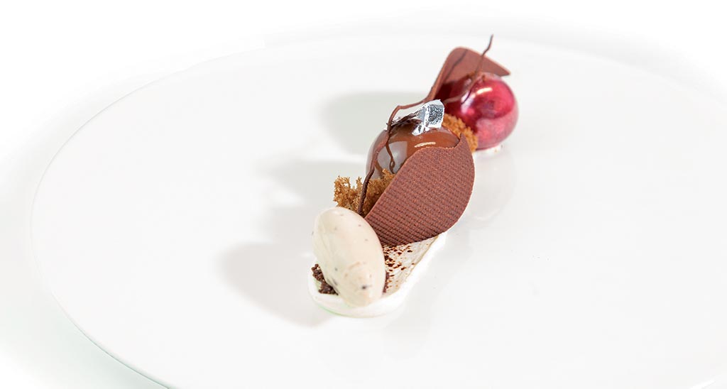 Dolce al cioccolato gourmet: sfera lucida, gelato, cialda croccante. Dessert elegante e raffinato.