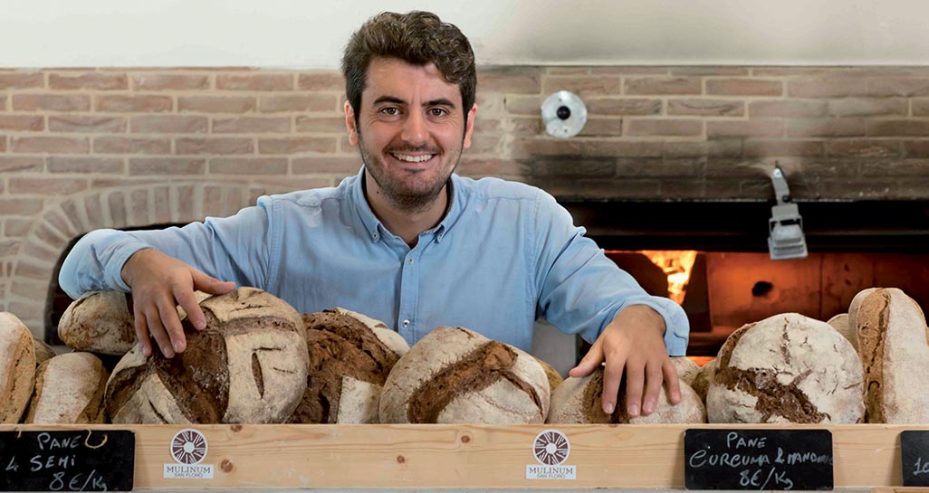 Stefano Caccavari, fondatore di Mulinum, con pane artigianale e forno a legna.