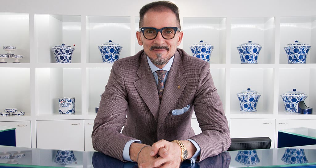 Nicola Fabbri, imprenditore italiano, in giacca. Vasi decorativi sullo sfondo. Marchio Fabbri 1905.