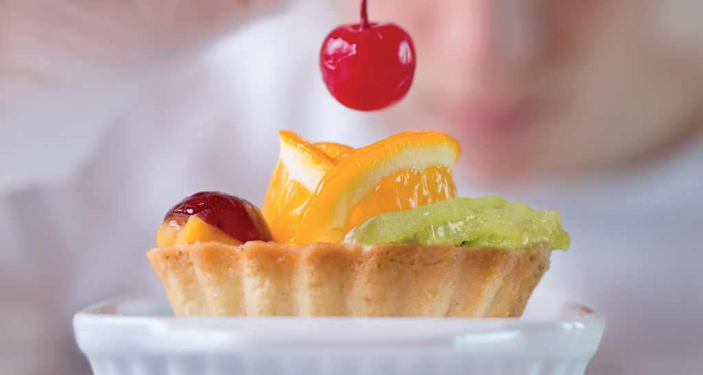 Mini torta di frutta fresca. Arancia, kiwi, ciliegia e altra frutta su crostata. Dolce monoporzione.