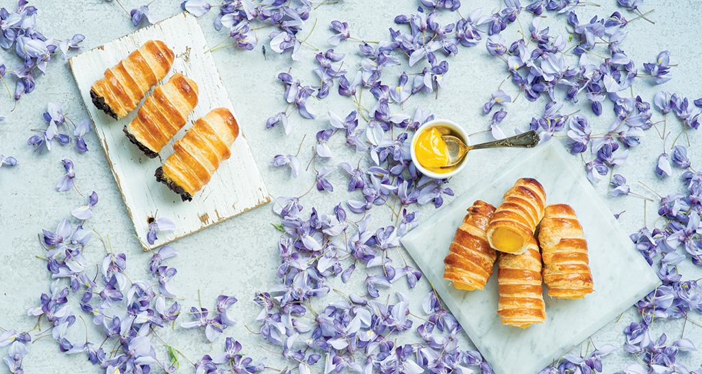 Cannoli italiani con crema e cioccolato. Pasticceria fresca su sfondo floreale. Dolci tipici.