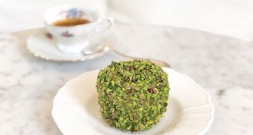 Dolce al pistacchio su piatto con tazzina di caffè. Pasticceria artigianale italiana.