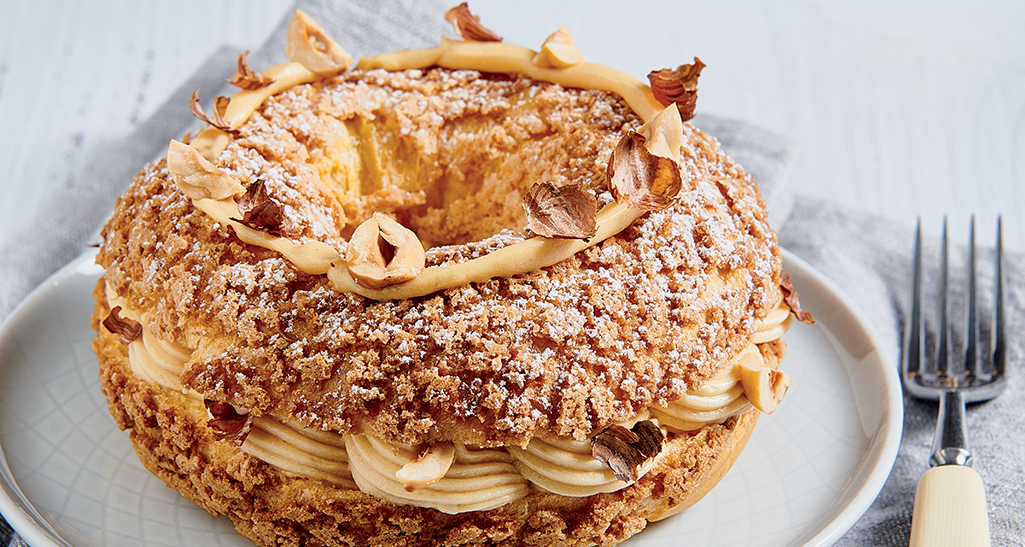 Paris-Brest invitante! Pasticceria francese con crema pralinata e nocciole. Dolce squisito, ideale per dessert.
