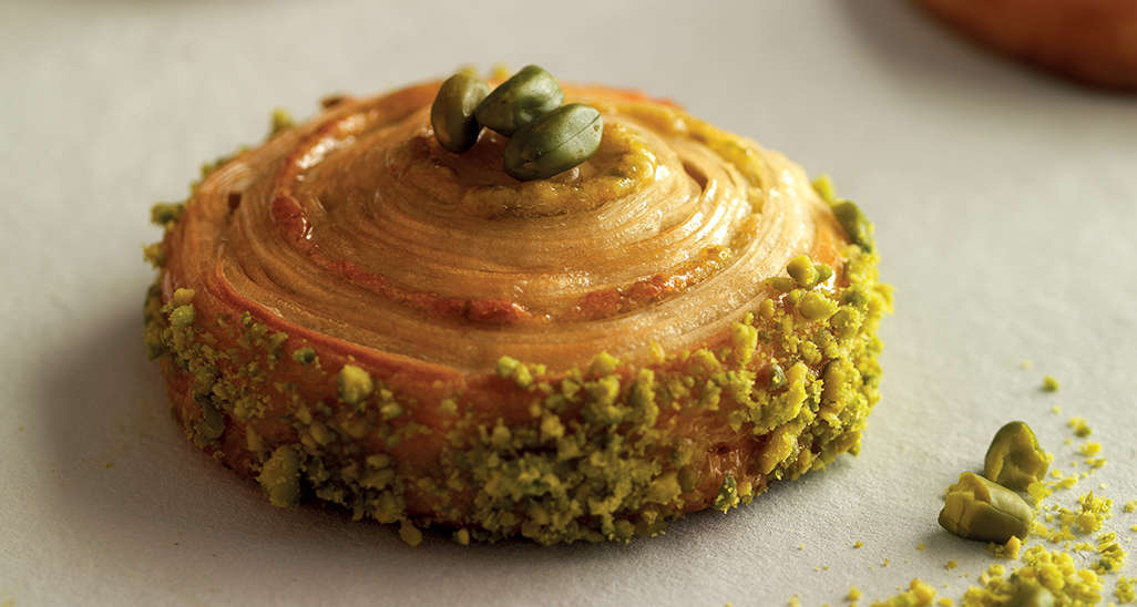Dolce a spirale con pistacchi. Pasticceria artigianale, dessert goloso, ideale per colazione o merenda. Specialità al pistacchio.