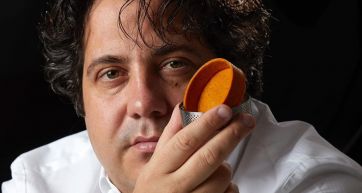 Chef con creazione culinaria arancione. Alta cucina, food design.