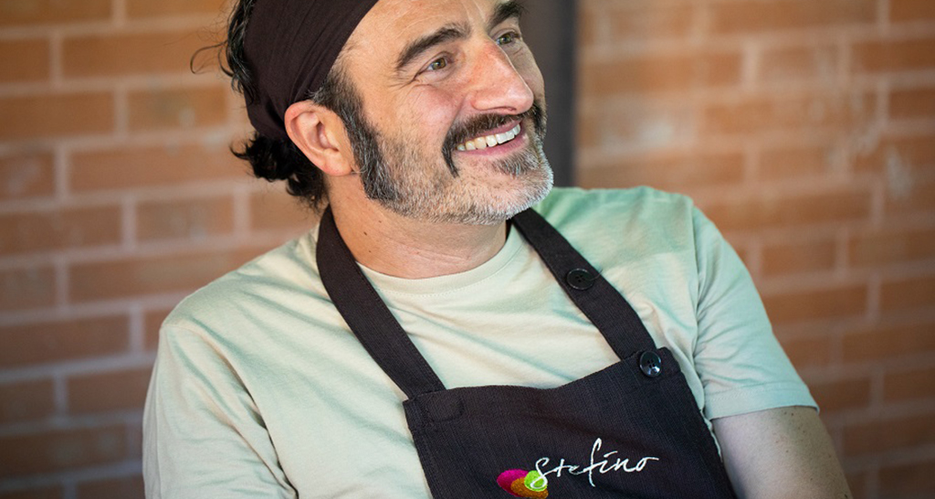 Chef sorridente con grembiule Stefino. Cucina italiana, chef italiano.