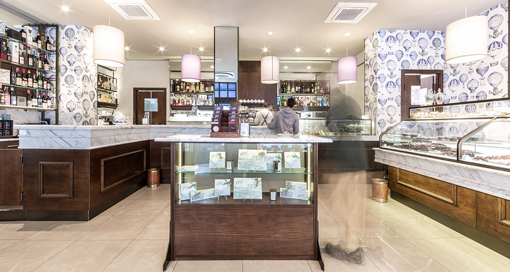 Interni pasticceria Clivati Milano. Arredamento elegante, vetrine dolci, bar fornito.