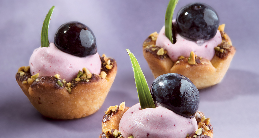 Mini tartellette con crema viola, ciliegia e pistacchi. Dolci monoporzione, pasticceria artigianale.