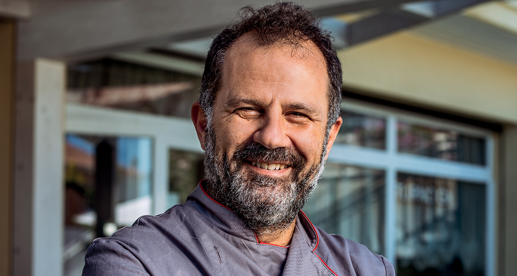 Ritratto di chef sorridente con barba. Cucina italiana, alta cucina, ristorante gourmet.