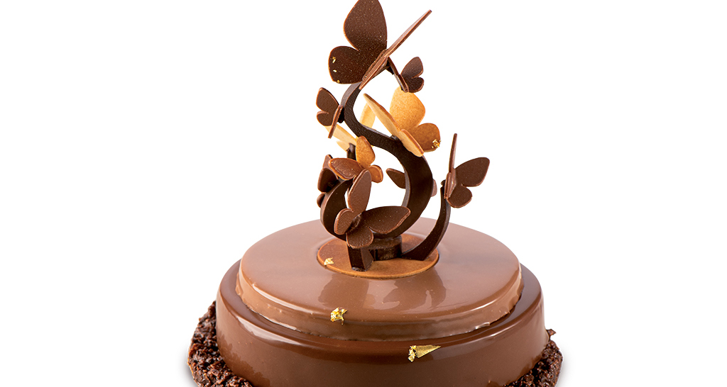 Elegante torta al cioccolato con decorazioni a farfalla. Pasticceria artigianale.