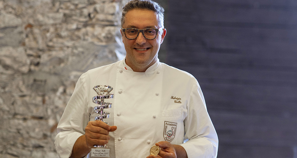Chef italiano premiato con trofeo. Fabrizio Galla, maestro pasticcere. Eccellenza culinaria italiana.