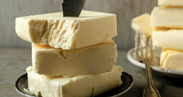 Burro artigianale a blocchi impilati con coltello. Burro di qualità per ricette.