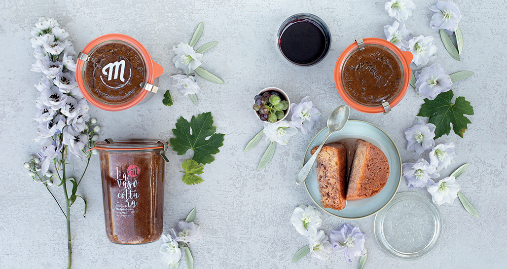 Marmellata artigianale in vasetti con fiori e uva. Dolce fatto in casa, colazione o merenda.
