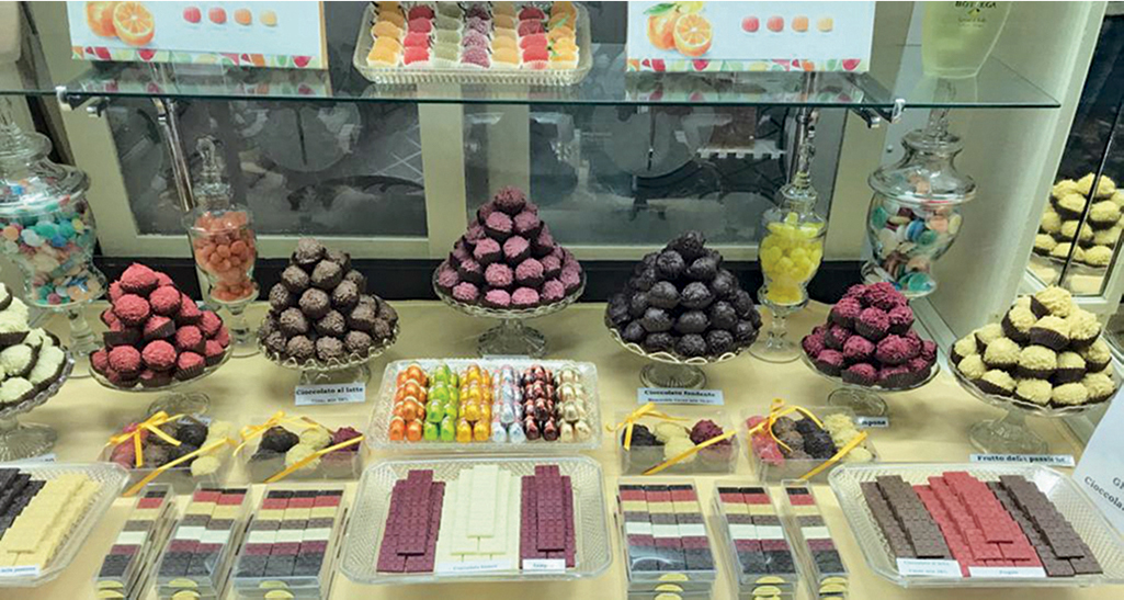 Vetrina pasticceria Lanfranchi: cioccolatini artigianali, praline assortite e dolciumi colorati. Delizie per il palato!