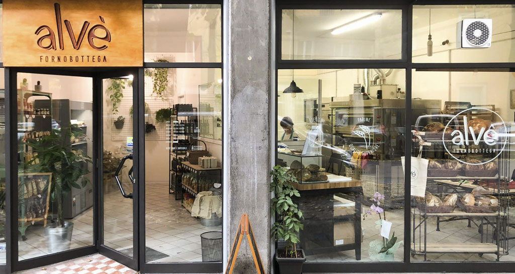 Vetrine di Alvé Fornobottega: pane artigianale, forno, prodotti locali. Design moderno, atmosfera accogliente.