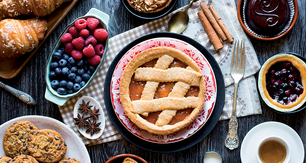Colazione dolce: crostata, croissant, biscotti, caffè e frutta fresca. Pasticceria artigianale italiana.