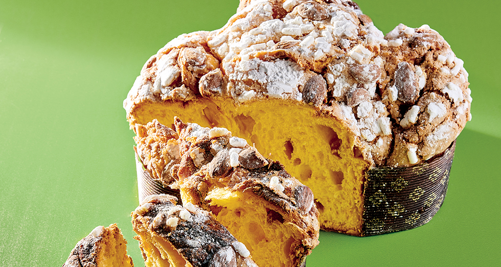 Colomba pasquale artigianale tagliata. Dolce tradizionale italiano con mandorle e glassa.